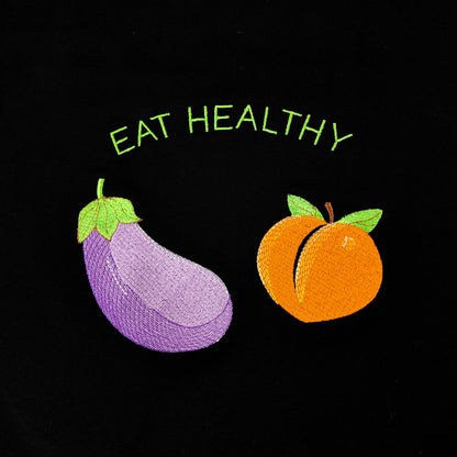 Black t-shirt with embroidered eggplant and peach graphic and the words Eat Healthy